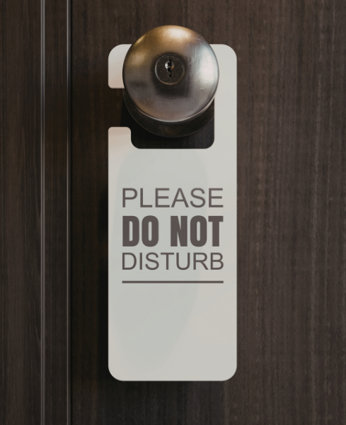 Cartello Please Do Not Disturb appeso alla maniglia della porta